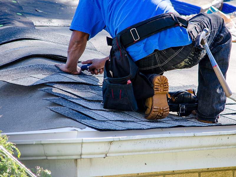 contractor close up replacing asphalt shingles for property roof maintenance chatsworth ga